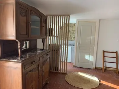 a kitchen with wooden cabinets and a rug on the floor at Chez LULU appartement de caractère in Cozzano