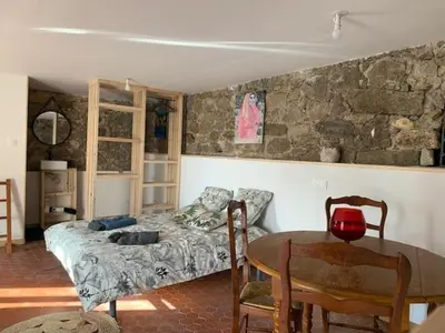 a bedroom with a bed and a table with chairs at Chez LULU appartement de caractère in Cozzano