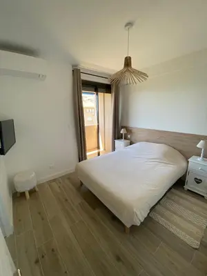 a bedroom with a large white bed and a window at Ajaccio magnifique T2 40m2 centre ville vue mer au bord de la plage neuf 5 personnes Clim wifi balcon parking privé fermé in Ajaccio