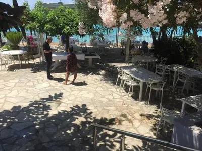 a man and a woman standing next to tables and chairs at Ajaccio magnifique T2 40m2 centre ville vue mer au bord de la plage neuf 5 personnes Clim wifi balcon parking privé fermé in Ajaccio