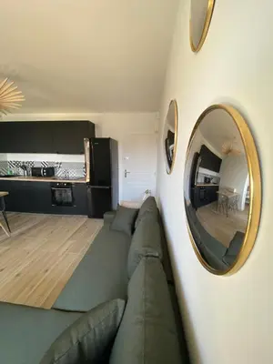 a living room with a couch and a mirror at Ajaccio magnifique T2 40m2 centre ville vue mer au bord de la plage neuf 5 personnes Clim wifi balcon parking privé fermé in Ajaccio