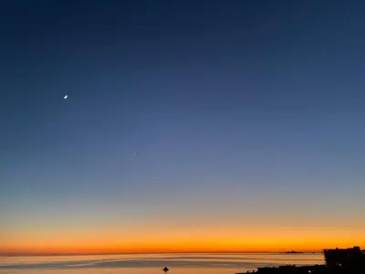 a view of the ocean at sunset at Ajaccio magnifique T2 40m2 centre ville vue mer au bord de la plage neuf 5 personnes Clim wifi balcon parking privé fermé in Ajaccio