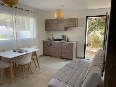 a kitchen with a couch and a table and a table and chairs at Les jardins de Saint Pancrace in Corte