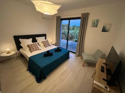 a bedroom with a bed and a television in it at Cala Rossa, Pinarello, Saint Cyprien - La Villa D'Alice in Lecci