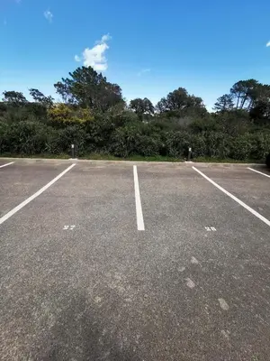 an empty parking lot with trees in the background at Cala Rossa, Pinarello, Saint Cyprien - La Villa D'Alice in Lecci