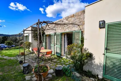 a house with green shutters and a patio at Villa Anastasia in Zilia