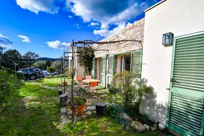 a garden outside a house with a table and chairs at Villa Anastasia in Zilia
