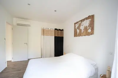 a bedroom with a white bed and a painting on the wall at Villa Anastasia in Zilia