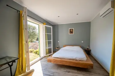 a bedroom with a bed and a large window at Villa Anastasia in Zilia