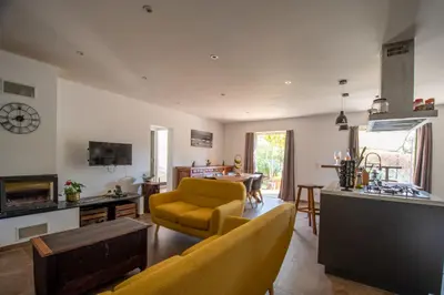 a living room with a yellow couch and a kitchen at Villa Anastasia in Zilia