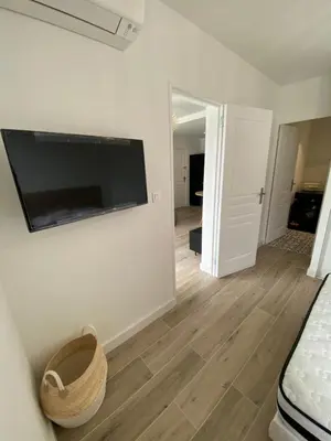a living room with a flat screen tv on a wall at Ajaccio magnifique T2 37m2 centre ville vue mer au bord de la plage Neuf 4 couchages balcon parking privé fermé Clim wifi in Ajaccio