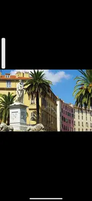 a statue in front of a building with palm trees at Ajaccio magnifique T2 37m2 centre ville vue mer au bord de la plage Neuf 4 couchages balcon parking privé fermé Clim wifi in Ajaccio