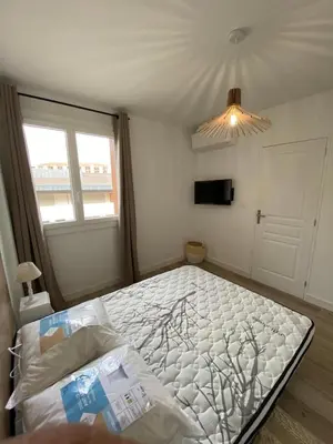 a bedroom with a large bed in a room at Ajaccio magnifique T2 37m2 centre ville vue mer au bord de la plage Neuf 4 couchages balcon parking privé fermé Clim wifi in Ajaccio