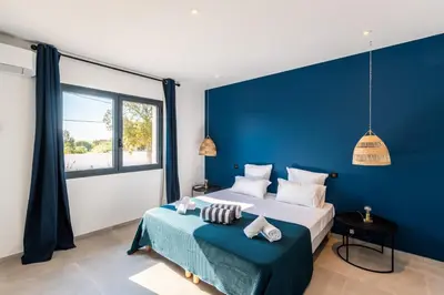 a blue bedroom with a bed with a blue wall at Villa Asphodede in Lecci