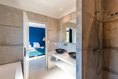 a bathroom with a sink and a shower and a bedroom at Villa Asphodede in Lecci