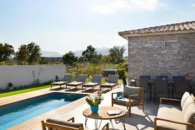 a patio with chairs and a swimming pool at Villa Asphodede in Lecci