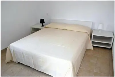 a bedroom with a white bed and two night stands at Residence Conca Blue in Conca