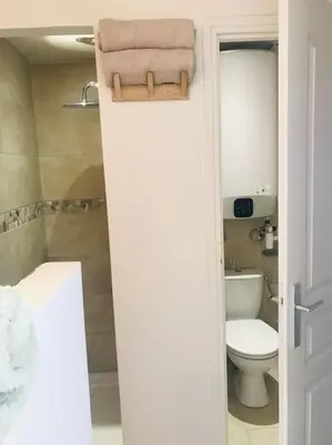 a bathroom with a toilet and a towel on the door at Petite Bergerie in Bonifacio