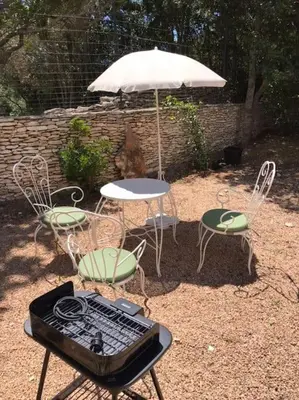 a table and chairs and an umbrella and a table and chairs at Petite Bergerie in Bonifacio