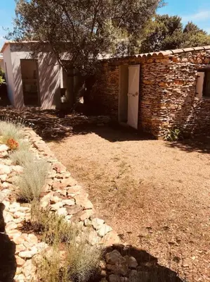 a brick building with a door in a yard at Petite Bergerie in Bonifacio
