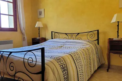 a bedroom with a bed with a black and white comforter at Maison avec piscine entre mer et montagne in Muro