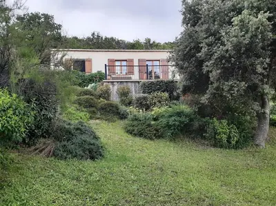 a house in the middle of a grassy field at Maison avec piscine entre mer et montagne in Muro