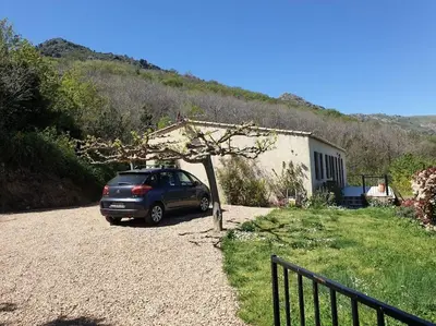 a car parked in the driveway of a house at Maison avec piscine entre mer et montagne in Muro