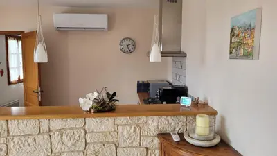 a kitchen with a counter and a clock on the wall at Maison avec piscine entre mer et montagne in Muro
