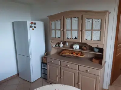 a kitchen with a refrigerator and a counter with a plate of food at Maison avec piscine entre mer et montagne in Muro