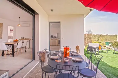 a dining table and chairs on a patio at Tramontana quiet place 7 min from beach swimming pool bbq in Calenzana