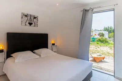 a bedroom with a bed and a large window at Tramontana quiet place 7 min from beach swimming pool bbq in Calenzana