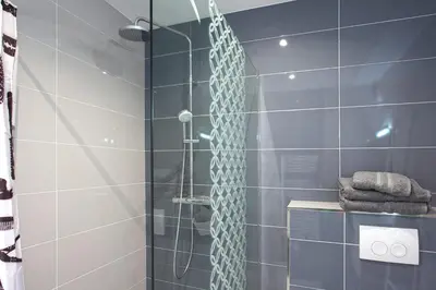 a bathroom with a shower with blue tiles at Tramontana quiet place 7 min from beach swimming pool bbq in Calenzana