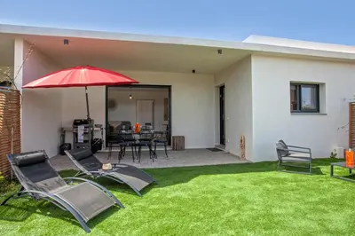 a patio with a red umbrella and chairs and a table at Tramontana quiet place 7 min from beach swimming pool bbq in Calenzana