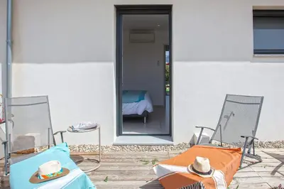two chairs with hats sitting on them on a patio at apart Levante shared swimming pool bbq in Calenzana