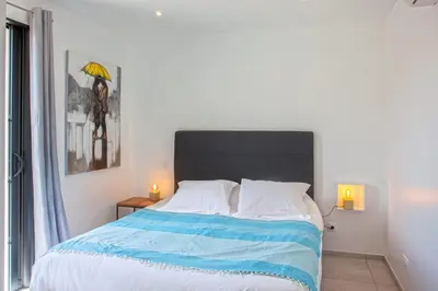 a bedroom with a large bed with a black headboard at apart Levante shared swimming pool bbq in Calenzana