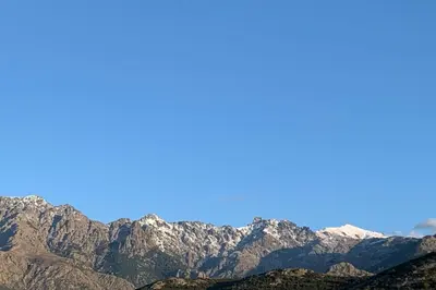 a view of a mountain range with snow at apart Levante shared swimming pool bbq in Calenzana
