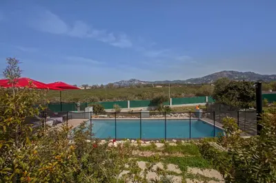a swimming pool with red umbrellas in a field at apart Levante shared swimming pool bbq in Calenzana
