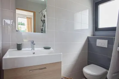 a bathroom with a white sink and a toilet at apart Levante shared swimming pool bbq in Calenzana
