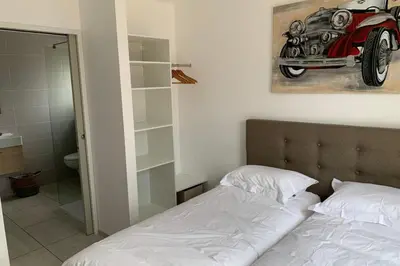 a bedroom with a bed and a picture of a car on the wall at appart Libeccio swimming pool bbq in Calenzana