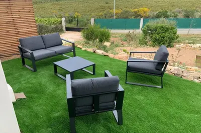 a yard with two chairs and a table on grass at appart Libeccio swimming pool bbq in Calenzana