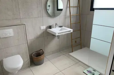 a bathroom with a sink and a toilet and a mirror at appart Libeccio swimming pool bbq in Calenzana