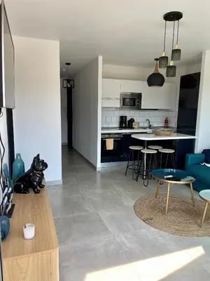 a kitchen and living room with a table and chairs at Superbe appartement sur le port, jacuzzi, piscine in Porto-Vecchio