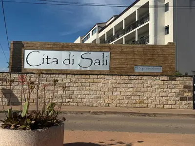 a sign on a brick wall in front of a building at Superbe appartement sur le port, jacuzzi, piscine in Porto-Vecchio