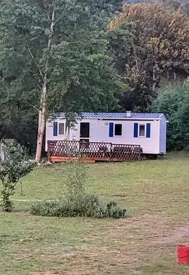 a white and blue trailer in a field at Le coin tranquille in Morosaglia