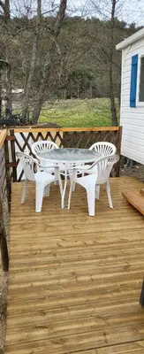 a patio with a table and two chairs on a deck at Le coin tranquille in Morosaglia