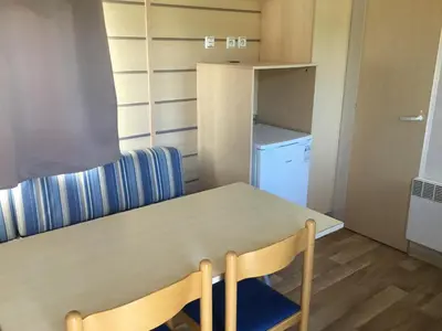 a small room with a table and a refrigerator at Le coin tranquille in Morosaglia