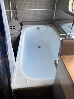 a white tub in a bathroom with a sink at La Caravane LE NID DOUILLET in Ponte-Leccia