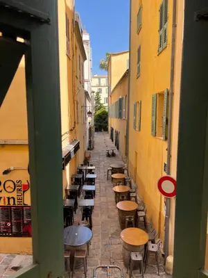 an alley with tables and chairs in an alley between buildings at Appartement T2 vieille ville d’Ajaccio in Ajaccio