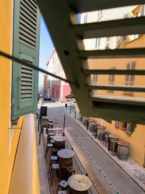 a row of wooden tables and stools on a street at Appartement T2 vieille ville d’Ajaccio in Ajaccio