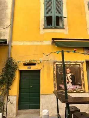 a building with a green door and a poster on it at Appartement T2 vieille ville d’Ajaccio in Ajaccio